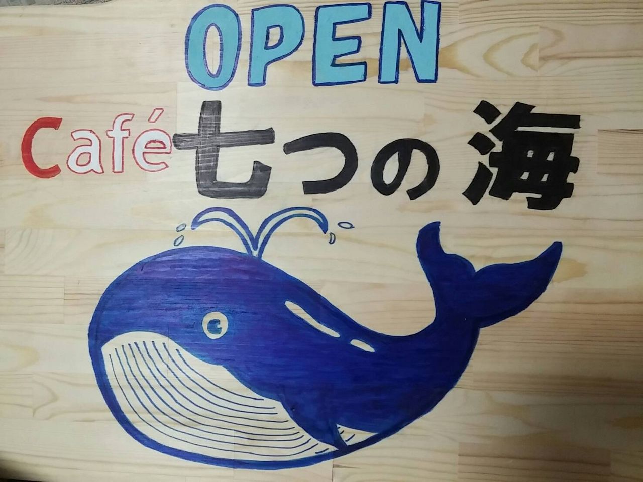クジラの絵が描かれた手作りの看板「OPEN Café 七つの海」
